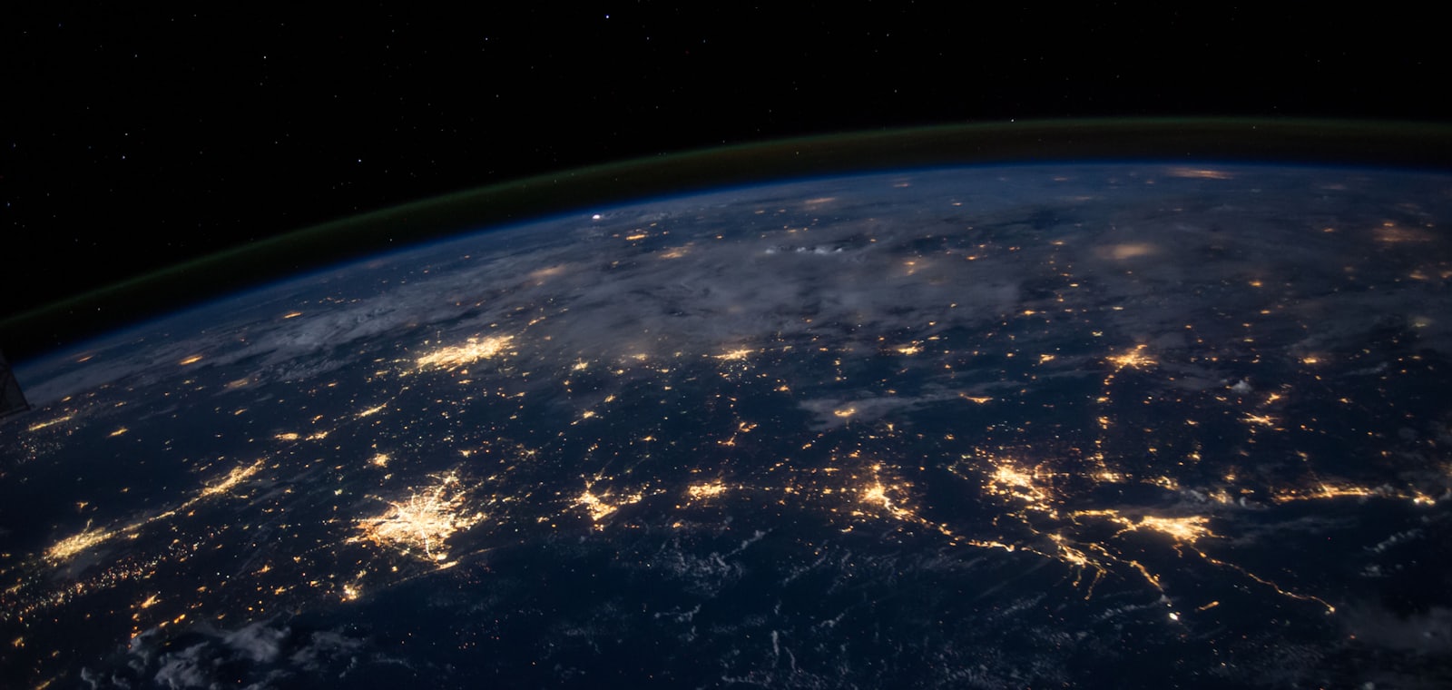 Vista da Terra à noite, com as luzes das cidades formando uma rede acesa